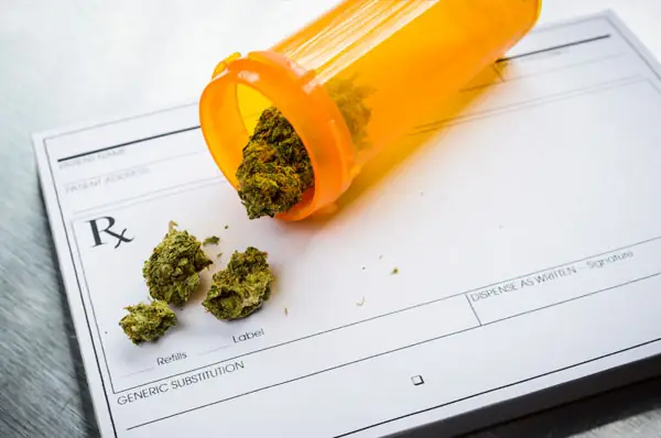 Almacenar marihuana medicinal en frasco de receta médica junto a flores de cannabis.